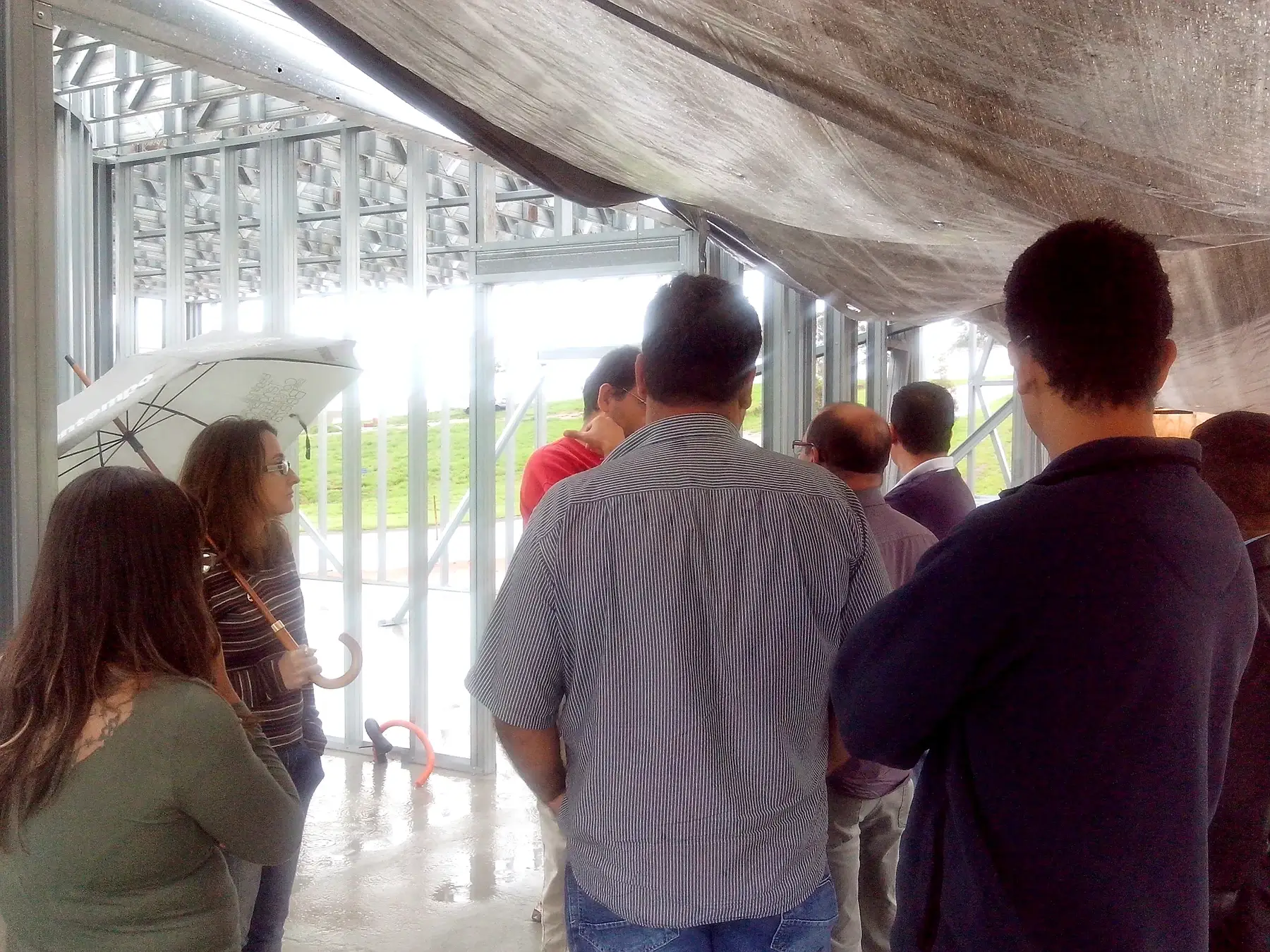 Grupo de visitantes dentro da estrutura da residência do Paratehy.